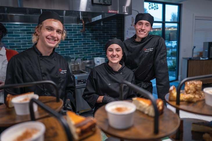 Culinary students smiling in the kitchen